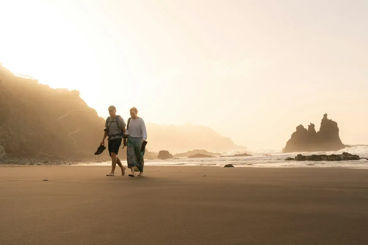 A retired couple walking together, calm and secure in retirement.